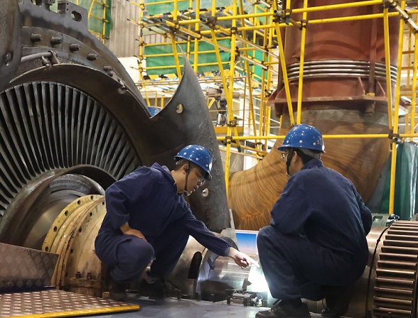 檢修部汽機(jī)車(chē)間本體班技術(shù)人員在研究螺栓切割方案。.jpg